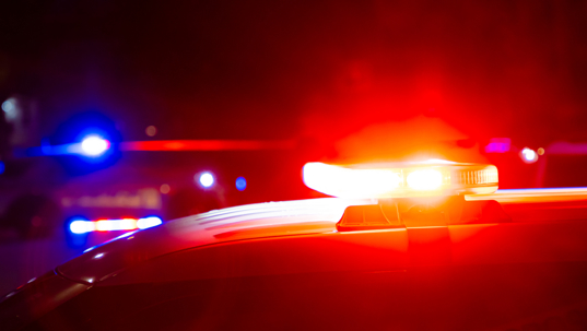 Red and blue police lights on a car at a crime scene at night with copy space.