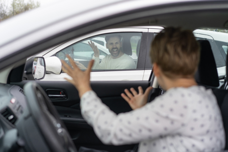 Two individuals appear to be arguing passionately from their cars, showcasing raw emotions in a confined space.